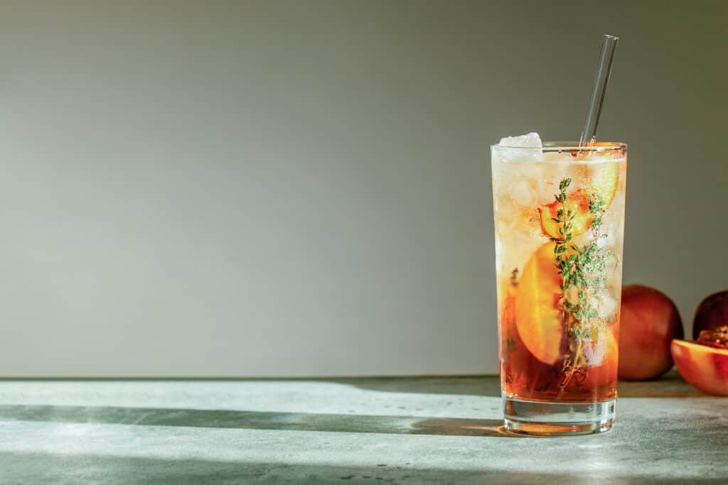 A glass of iced tea with thyme illustrates cocktail gardening with fresh herbs